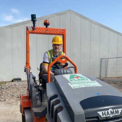 Student Lucas Burke sitting on plant machinery on a building site