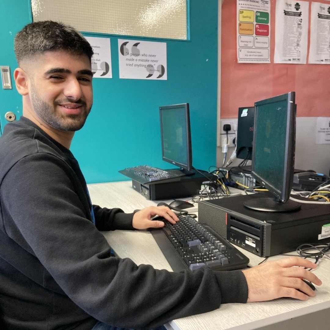 Business student Harjot Tiwna sitting at a desktop PC