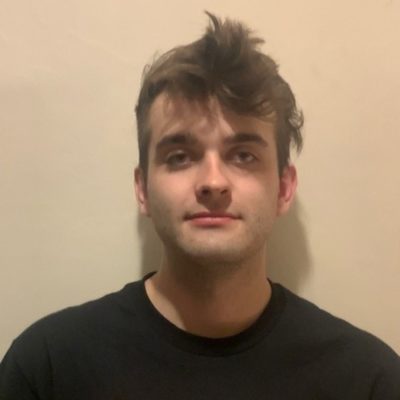 head shot of Student Adam Cater, wearing a black top and standing in front of a white background