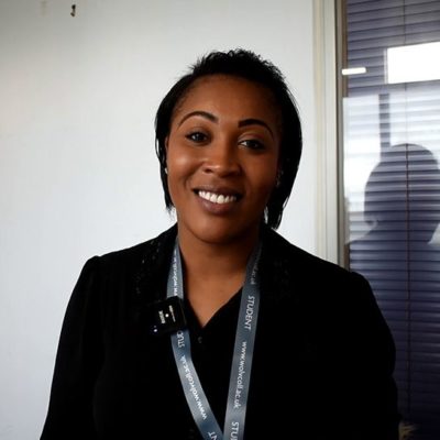 Student Hasina Riley wearing a black top and a grey college lanyard