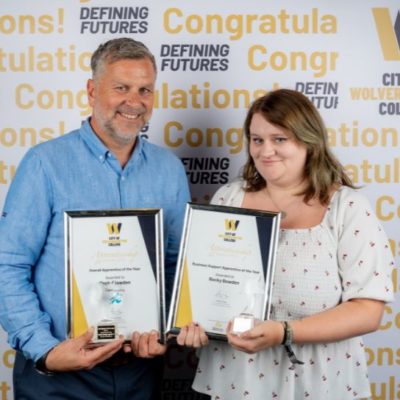 Apprentice of the Year, Becky Bowden, wearing a white top, holding a certificate and trophy with John Harper, managing director of Complesso Healthcare Solutions wearing a blue shirt.