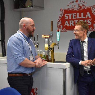 Andy Street, mayor of the West Midlands, right, wearing a dark blue suit and tie chats to a guest at the launch of the college's Drinks Dispense Academy