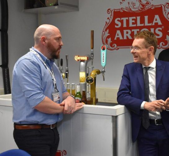 Andy Street, mayor of the West Midlands, right, wearing a dark blue suit and tie chats to a guest at the launch of the college's Drinks Dispense Academy