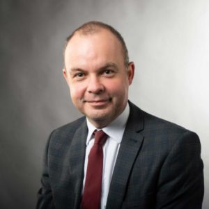Richard Hewitt, head of apprenticeships wearing a dark jacket, white shirt and dark red tie